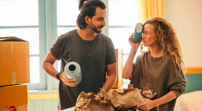 
Diverse couple unpacking fragile items after relocating