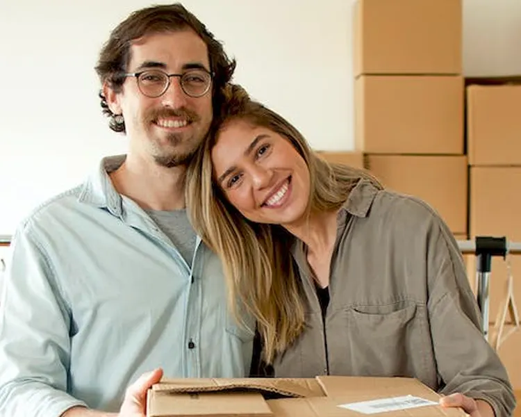 
Thoughtful couple writing in notebook while moving house 
