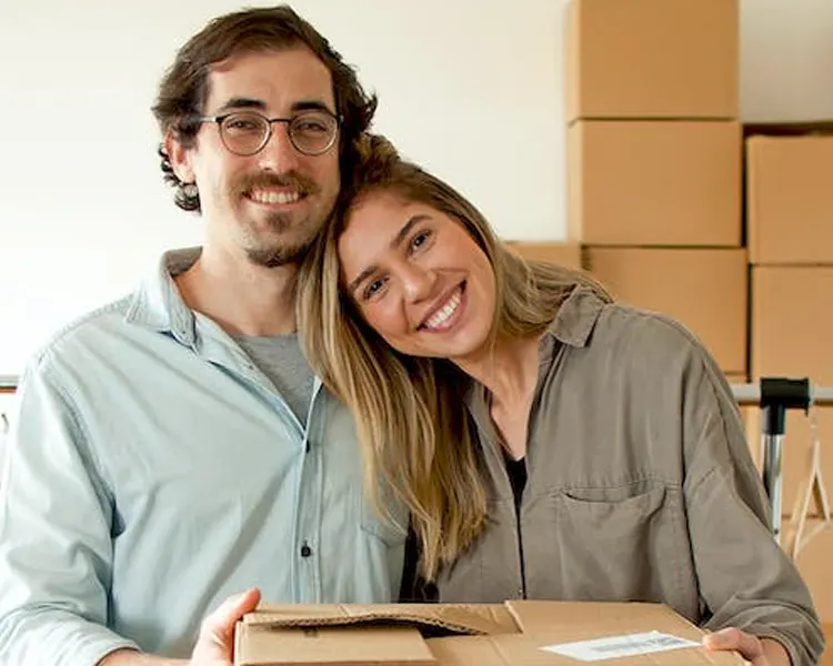 
Thoughtful couple writing in notebook while moving house 